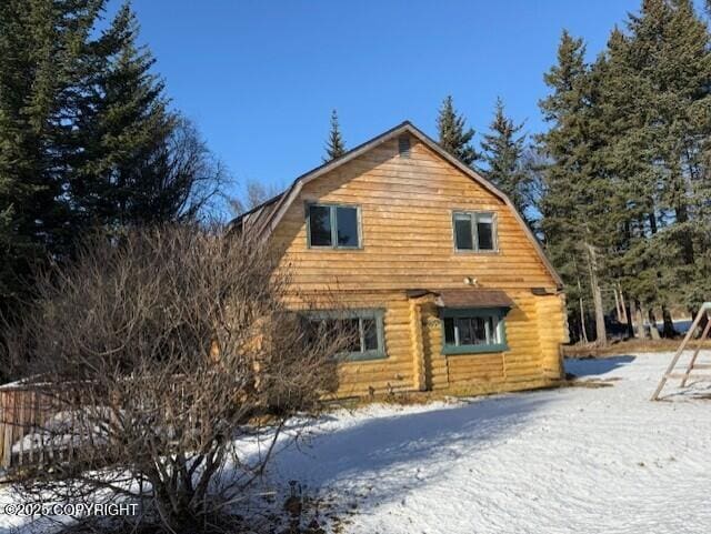 snow covered property with a gambrel roof