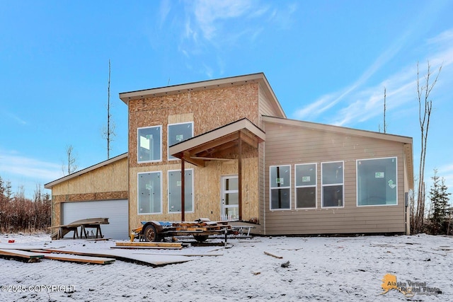 snow covered rear of property featuring stucco siding