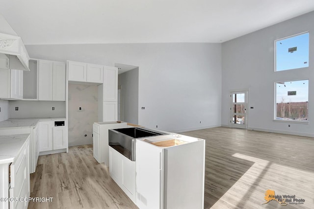 kitchen with light wood finished floors, white cabinetry, and a center island