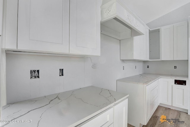 clothes washing area featuring light wood-type flooring