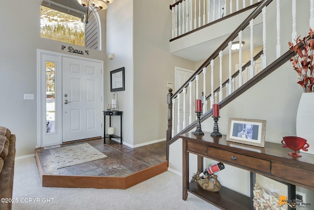 20420 Williamsburg Dr, Eagle River, AK 99577 - foyer with a high ceiling, baseboards, stone tile floors, stairway, and carpet flooring