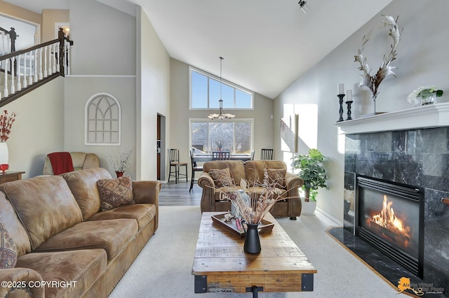 20420 Williamsburg Dr, Eagle River, AK 99577 - living room with high vaulted ceiling, a tiled fireplace, a chandelier, and stairway