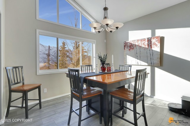20420 Williamsburg Dr, Eagle River, AK 99577 - dining area with a chandelier, wood finished floors, a towering ceiling, and baseboards