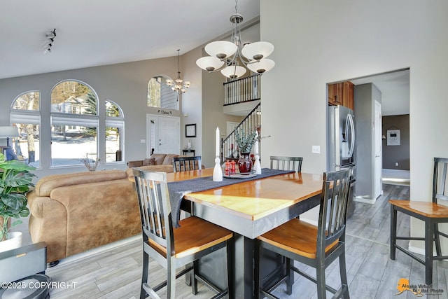 20420 Williamsburg Dr, Eagle River, AK 99577 - dining room featuring a chandelier, high vaulted ceiling, stairway, light wood-style flooring, and track lighting