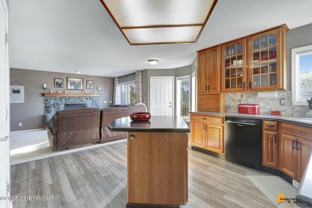 20420 Williamsburg Dr, Eagle River, AK 99577 - kitchen featuring dishwasher, light wood-style floors, a kitchen island, brown cabinetry, and a stone fireplace