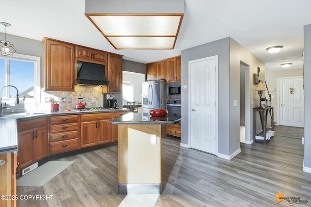 20420 Williamsburg Dr, Eagle River, AK 99577 - kitchen with extractor fan, stainless steel appliances, a sink, tasteful backsplash, and light wood finished floors