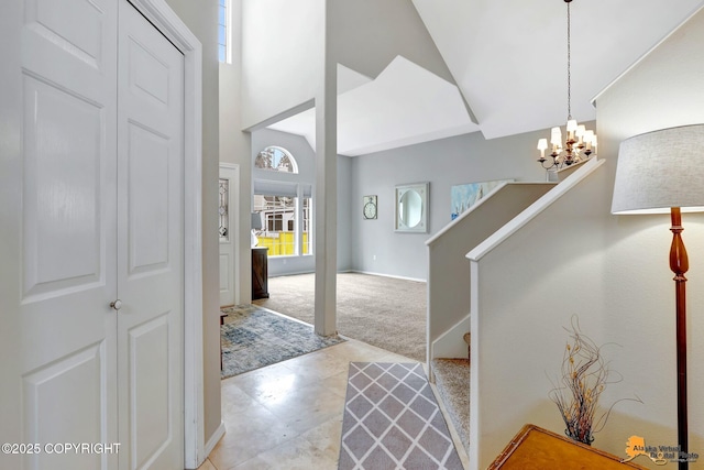 foyer entrance featuring light colored carpet, a towering ceiling, an inviting chandelier, baseboards, and stairs