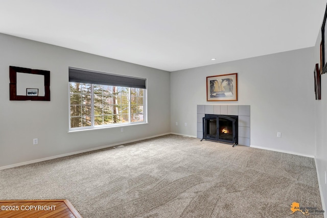 unfurnished living room with a fireplace, carpet flooring, visible vents, and baseboards