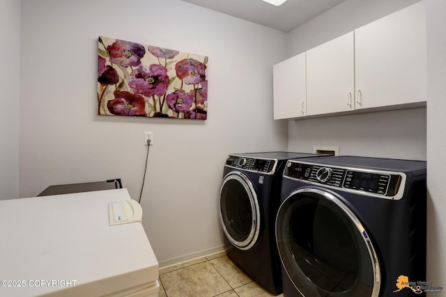 laundry room with light tile patterned floors, washing machine and dryer, cabinet space, and baseboards