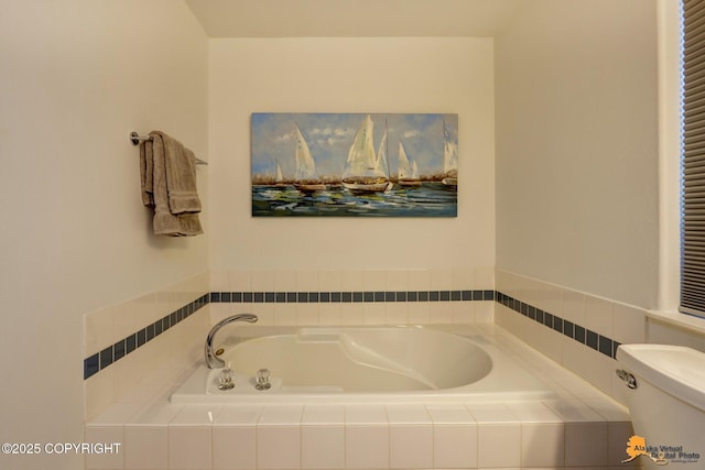 bathroom with a garden tub and toilet