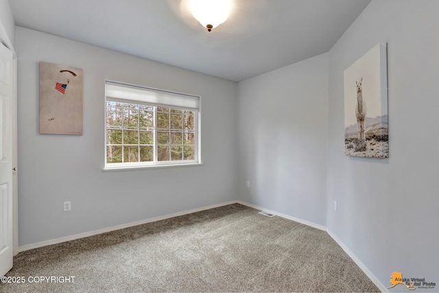 carpeted empty room featuring baseboards