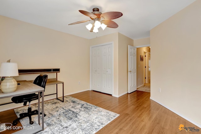 home office with light wood-style floors, baseboards, and a ceiling fan