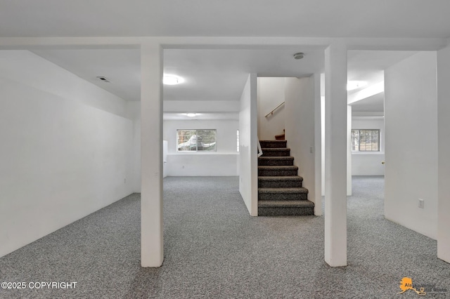 interior space with carpet floors, plenty of natural light, stairs, and visible vents