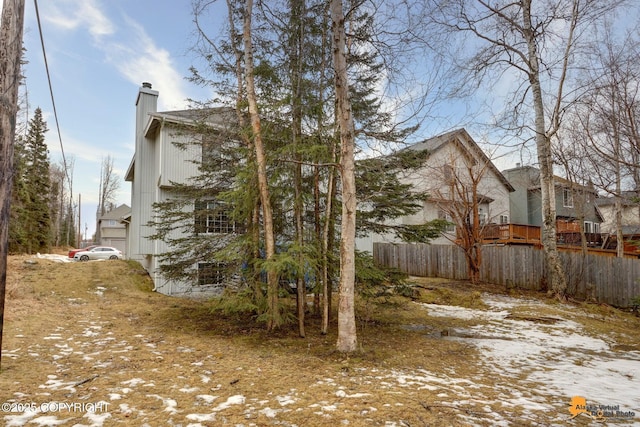 view of property exterior with a chimney and fence