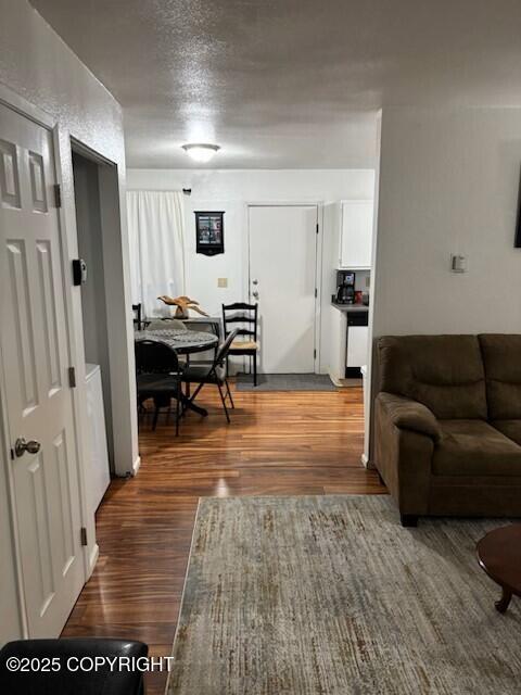 interior space with a textured ceiling and wood finished floors