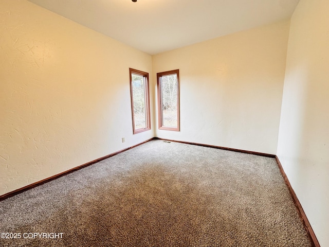 unfurnished room with baseboards and carpet flooring