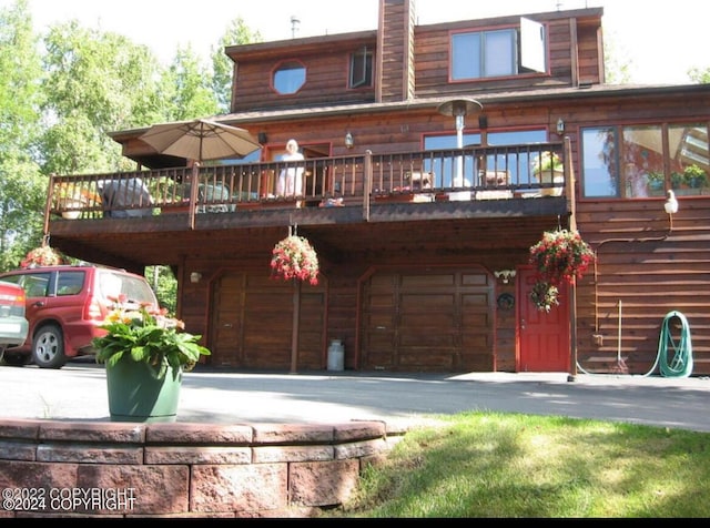 rear view of house featuring an attached garage and aphalt driveway