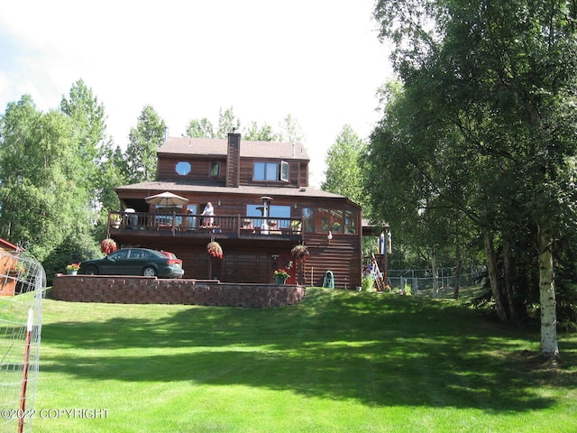 back of house featuring a yard and a wooden deck