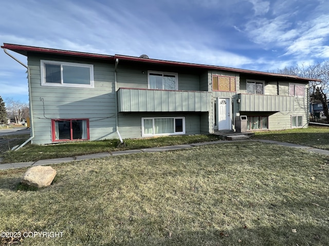 view of front of home featuring a balcony and a front lawn