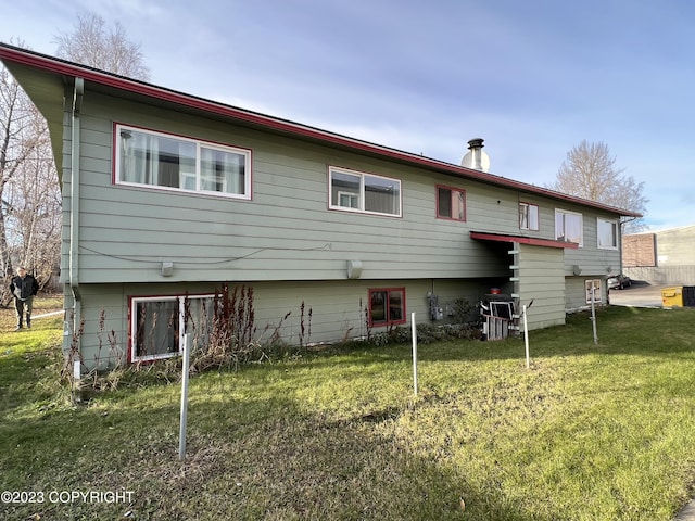 rear view of house featuring a yard