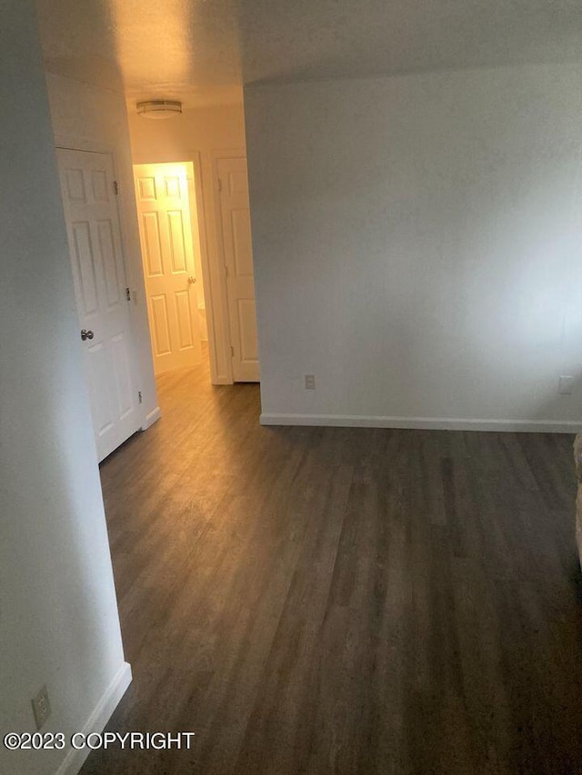 unfurnished room with baseboards and wood finished floors