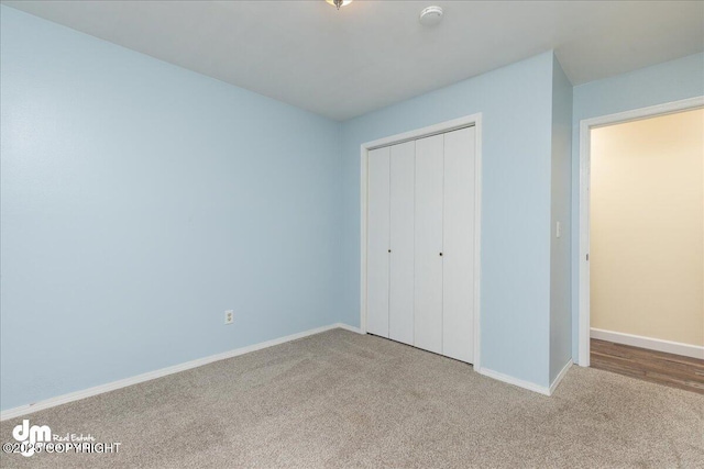 unfurnished bedroom with baseboards, a closet, and carpet floors