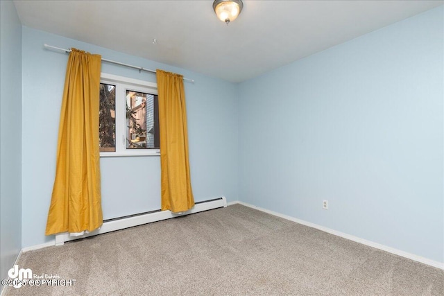 carpeted spare room with a baseboard heating unit and baseboards