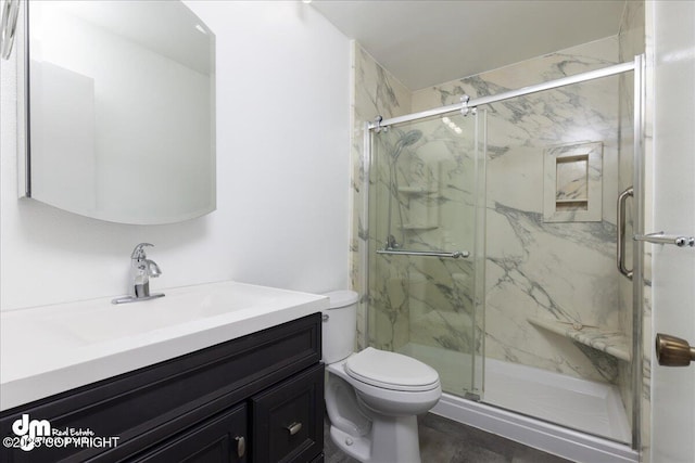 bathroom featuring a marble finish shower, toilet, and vanity