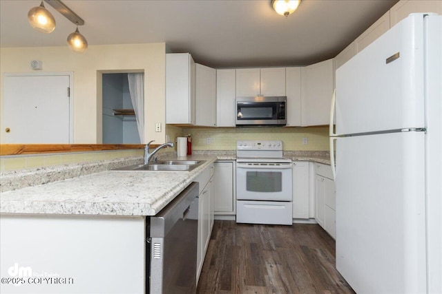 kitchen featuring a sink, backsplash, dark wood finished floors, appliances with stainless steel finishes, and light countertops