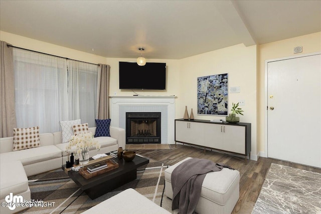 living area featuring a tile fireplace and wood finished floors