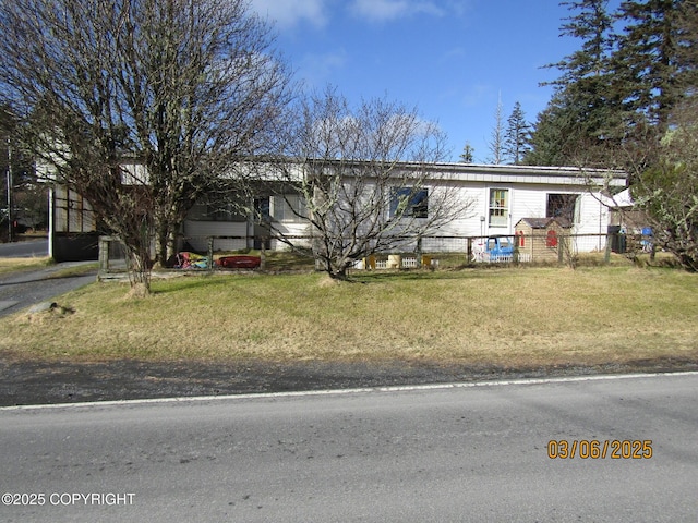 view of front of home with a front yard and fence