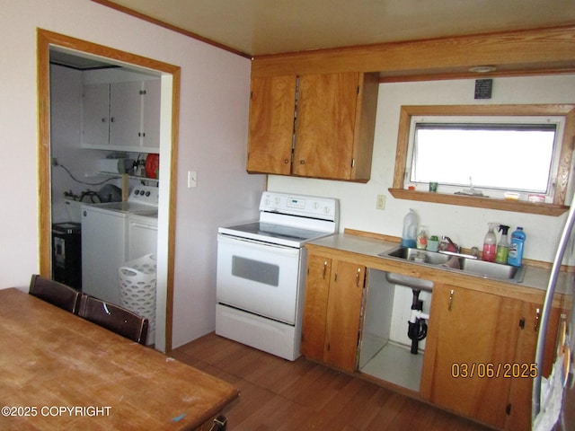 kitchen featuring wood finished floors, independent washer and dryer, light countertops, white electric range, and a sink