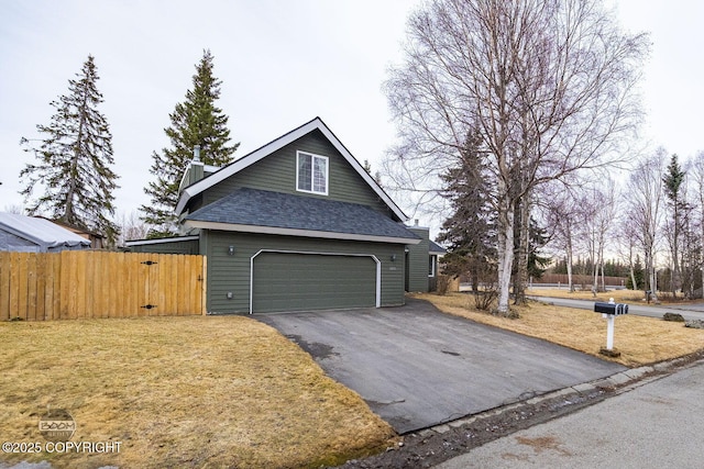 exterior space featuring a front lawn, fence, roof with shingles, a chimney, and driveway