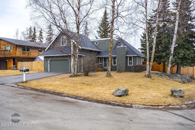 view of front of house featuring a front lawn, driveway, and fence