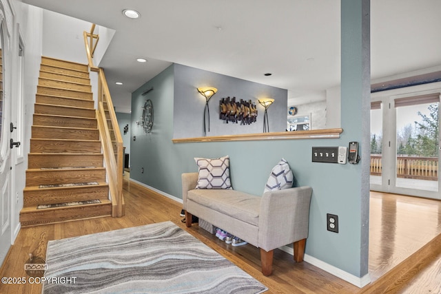 living area featuring recessed lighting, baseboards, wood finished floors, and stairs