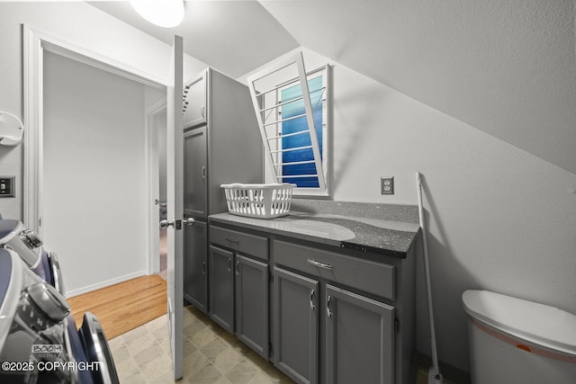 bathroom with vanity, lofted ceiling, and toilet