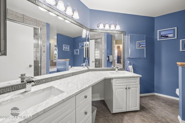 bathroom featuring double vanity, a stall shower, and a sink