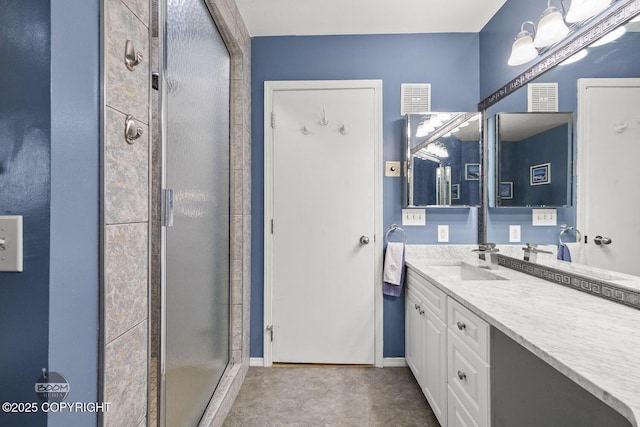 bathroom with visible vents, a shower stall, vanity, and baseboards