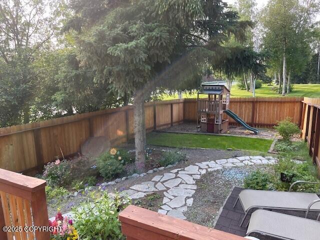 view of yard with a fenced backyard and a playground