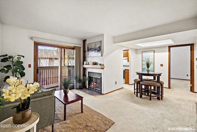 living room with a fireplace with flush hearth, light colored carpet, and baseboards