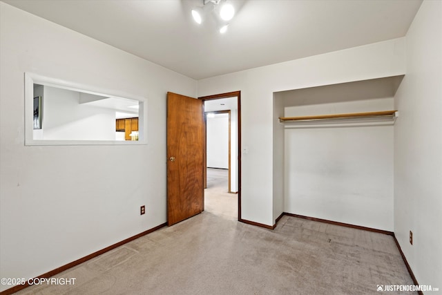 unfurnished bedroom featuring carpet floors, baseboards, and a closet