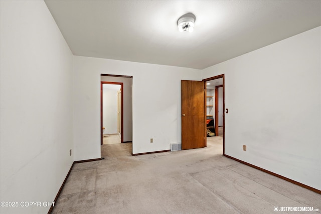 unfurnished room with carpet flooring, visible vents, and baseboards