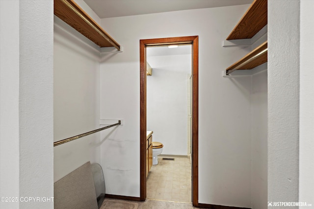 spacious closet with light floors and visible vents