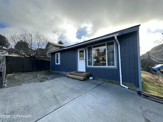 view of front of property featuring a patio and fence