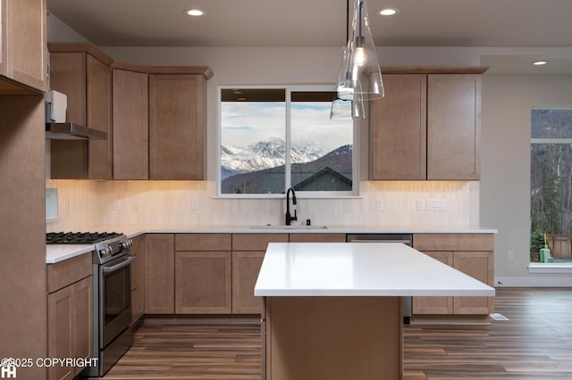 kitchen with dark wood-type flooring, stainless steel gas stove, a sink, and backsplash