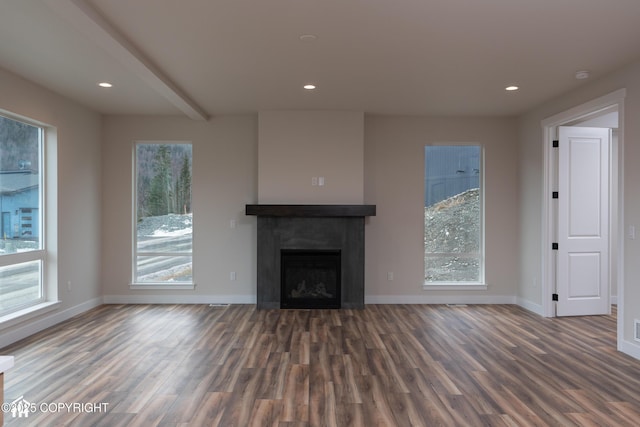 unfurnished living room featuring a wealth of natural light, a fireplace, baseboards, and wood finished floors