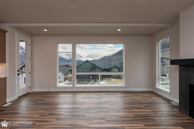 unfurnished dining area with baseboards, dark wood-style flooring, and recessed lighting