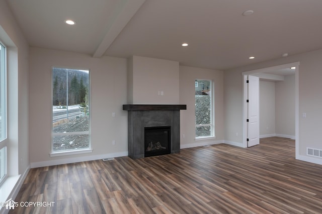 unfurnished living room with visible vents, wood finished floors, a fireplace, a wealth of natural light, and recessed lighting