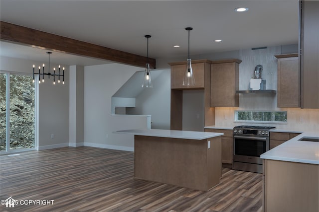 kitchen with stainless steel gas stove, baseboards, beamed ceiling, a center island, and light countertops