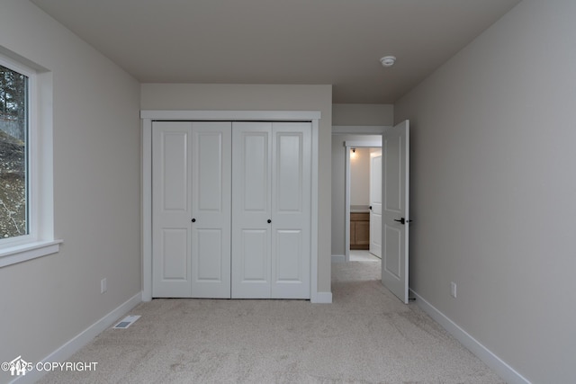 unfurnished bedroom with carpet floors, baseboards, and visible vents